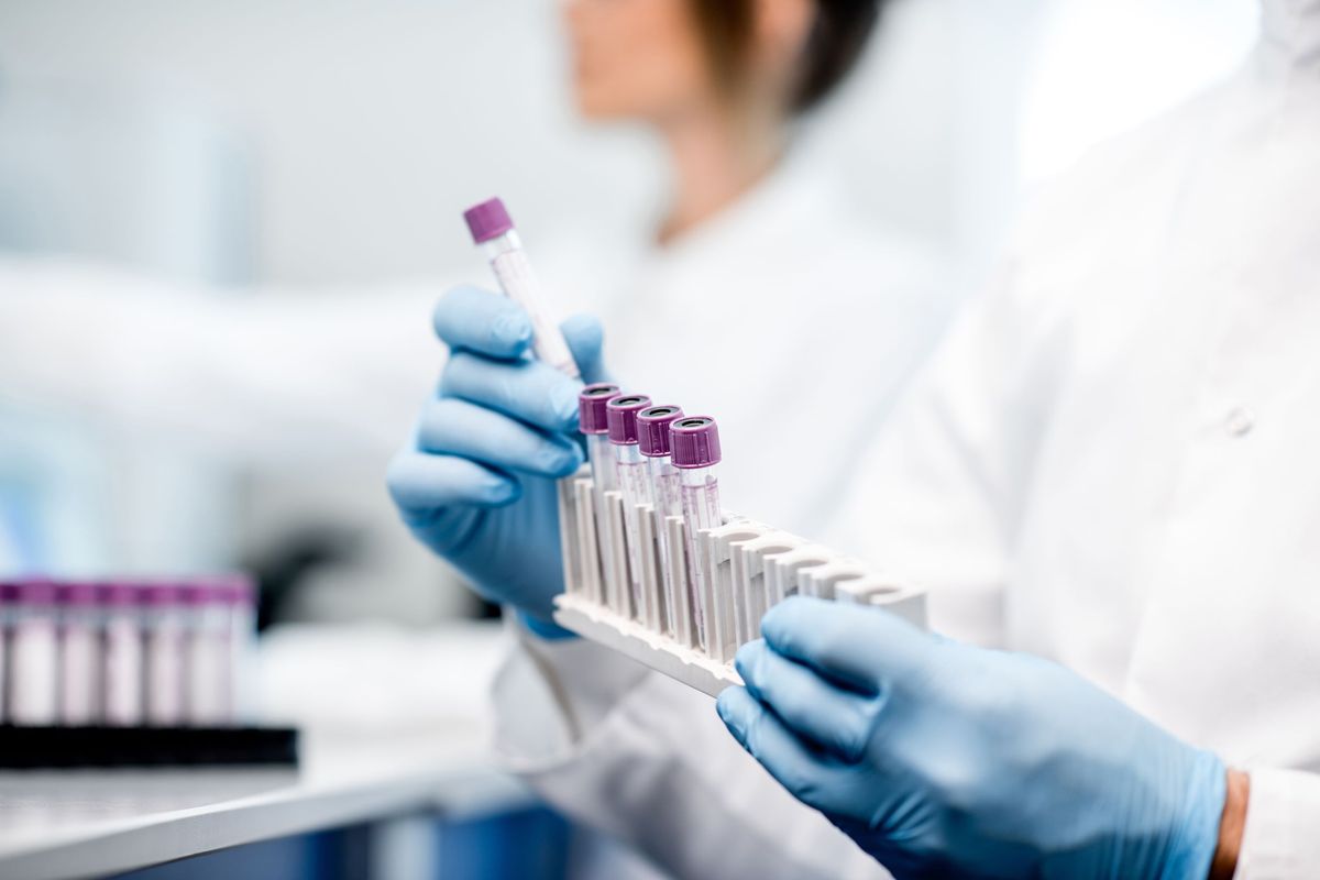 A person holding lab test samples.