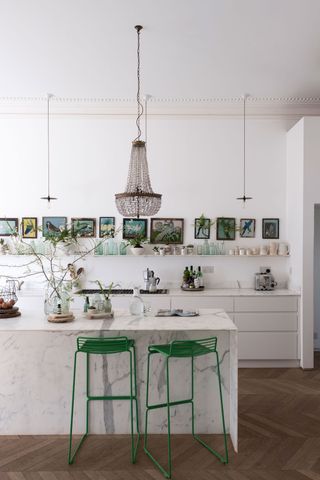 A kitchen island lighting idea over a marble island with a unique statement chandelier above it in a South London home.