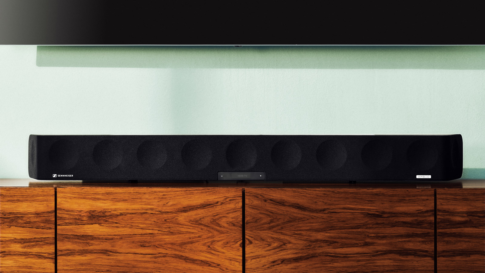 Sennheiser Ambeo Soundbar Max on a wooden entertainment unit.