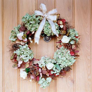 christmas wreath with flower and leaves on door