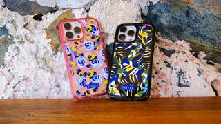 A pair of colorful OtterBox phone cases leaning against a wall