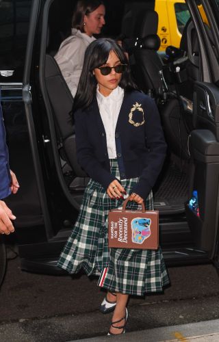 Jenna Ortega is seen arriving at her hotel on August 19, 2024 in New York, New York wearing an outfit made up of a plaid long skirt and blue cardigan that resumbles Winona Ryder's outfit at the end of Beetlejuice.