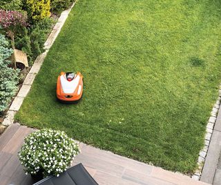 Birdseye photo of a small rectangular lawn being cut by a robot lawnmower