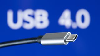 A USB 4 cable infront of a blug and white USB 4.0 logo