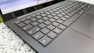 Samsung Galaxy Chromebook Plus sitting on wall with close up of keyboard