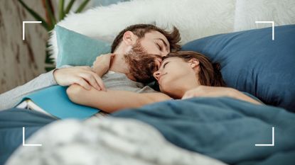 Man kissing girlfriend in bed, holding book on stomach, representing the helicopter sex position