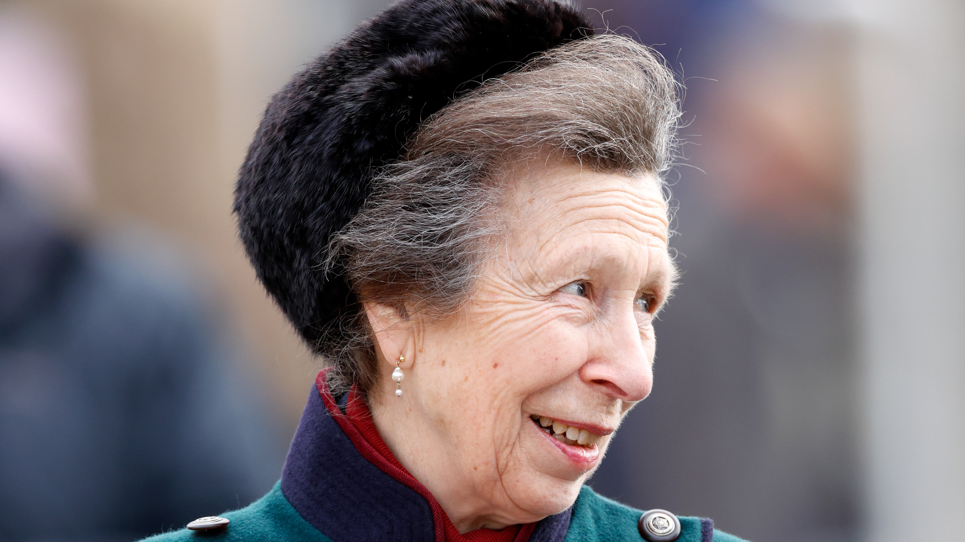 Princess Anne wearing a green coat and fur hat smiling