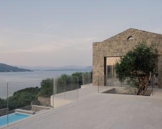 Corfu House minimalist interior and stone exterior with swimming pool looking to the sea