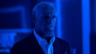 Sir Reginald Hargreeves stands in a room with blue lighting in The Umbrella Academy season 4