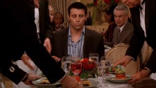 Joey (Matt LeBlanc) looks at a table full of food on an episode of Friends.