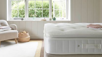 A thick memory foam mattress on a bed base with a thick mattress topper 