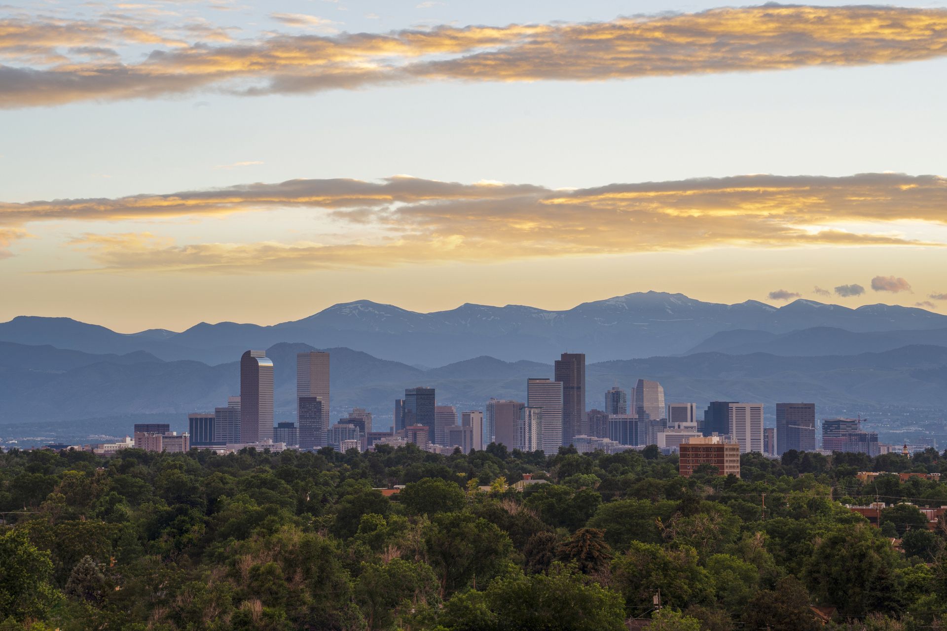 The skyline of Denver with mountains in the background.