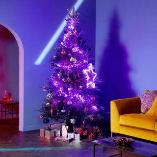 room with blue walls christmas tree and gift boxes