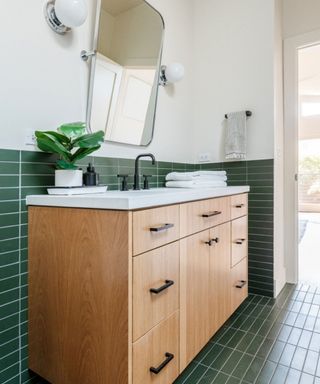 A green and white bathroom with an unfitted wooden vanity cabinet