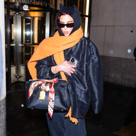 Dua Lipa wearing an oversized scarf with a black hoodie and a Hermes Birkin bag 