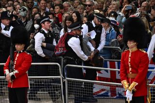British police escort protestors away from the Mall during the Queen's Birthday Parade, the Trooping the Colour, as part of Queen Elizabeth II's platinum jubilee celebrations, in London on June 2, 2022