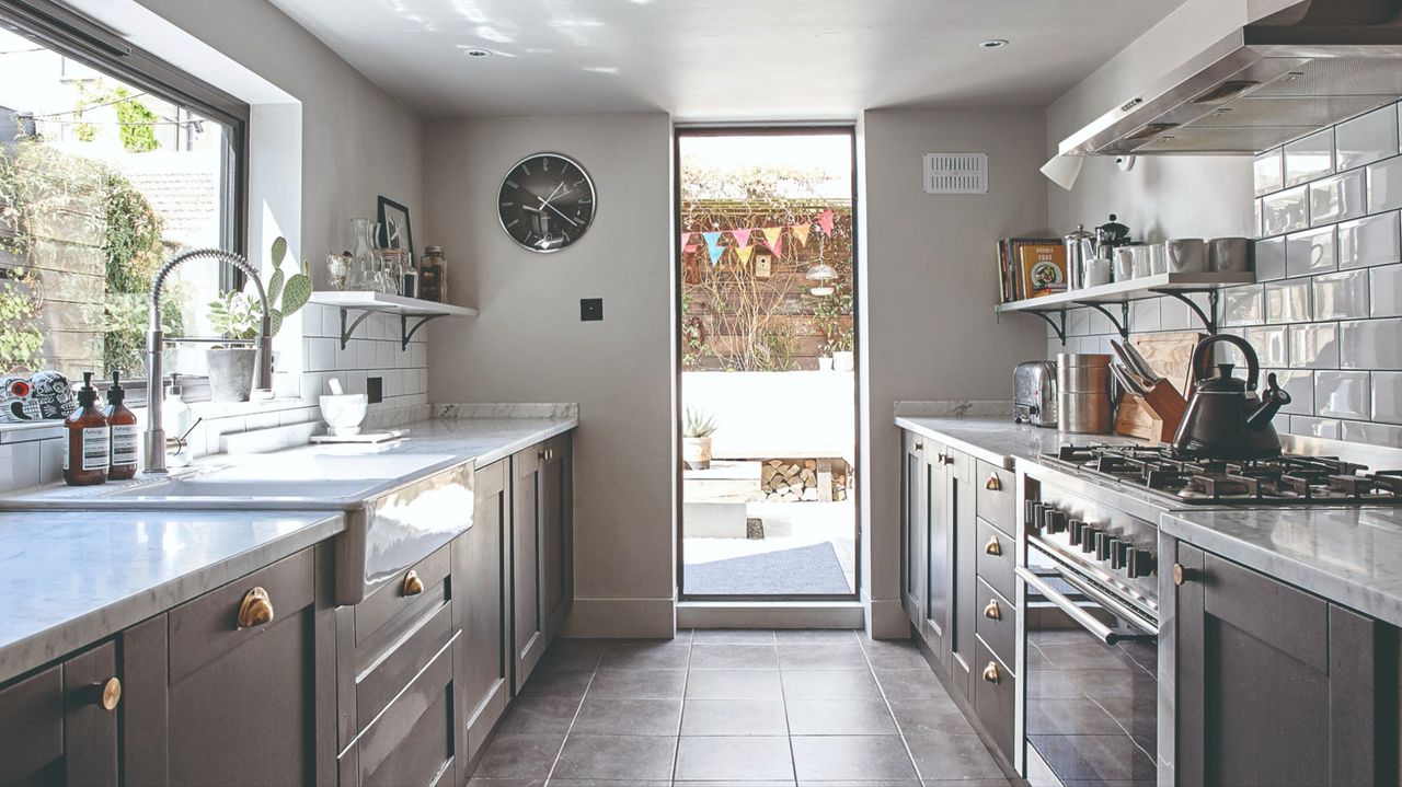 Galley kitchen with dark Shaker units, dark slate floor tiles and ceiling-to-floor picture window