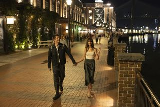 nicholas galitzine as hayes campbell and anne hathaway as solene, walking down a riverside street at night, in 'the idea of you'
