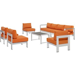 Outdoor furniture set with white frames and orange cushions