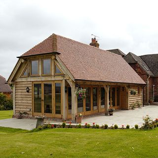 exterior of house with clay roof tiles wooden and glass door with garden