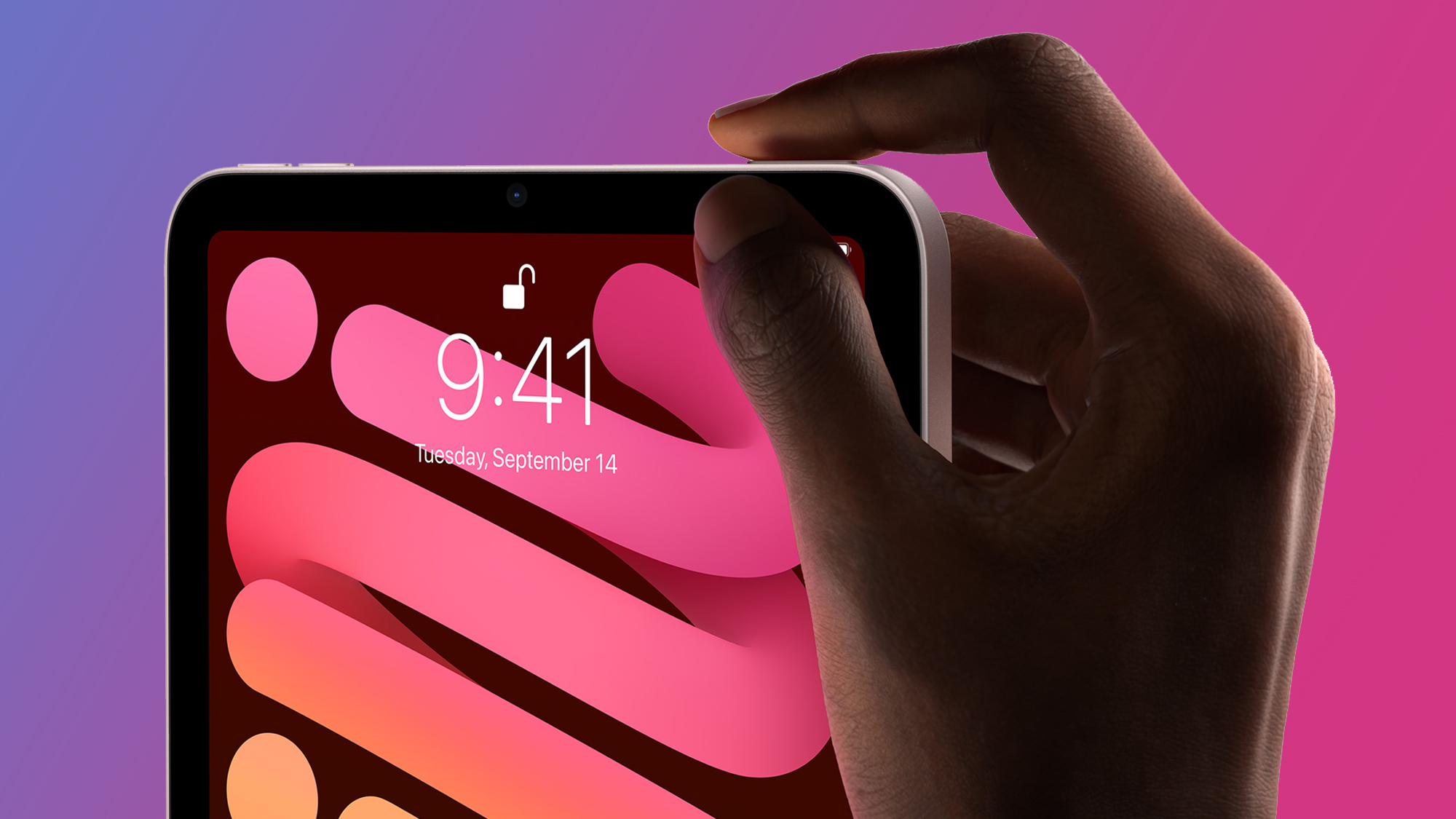 Hand using Touch ID on iPad mini 6 on purple and pink background