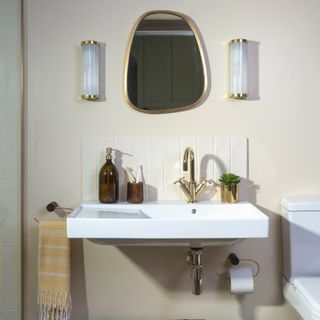 Bathroom with glass wall lights flanking mirror