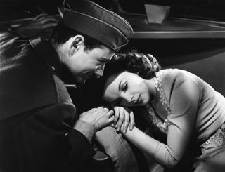 judy garland rests her head on a couch while robert walker consoles her in The Clock