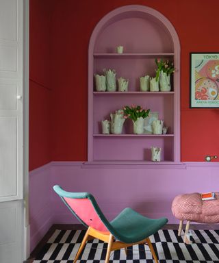 red and pink living room with alcove painted pink, black and white rug, modern chair, artwork