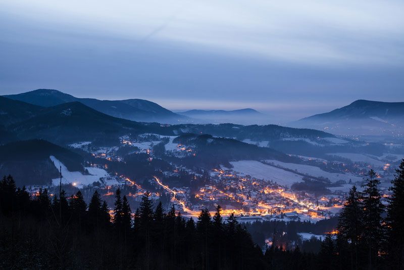 Landscape photo of a village at nighttime in winter.