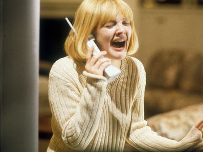 Drew Barrymore in Scream screams into a phone with a cute blonde short bob