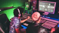 Musician and sound engineer mixing new album inside boutique recording studio