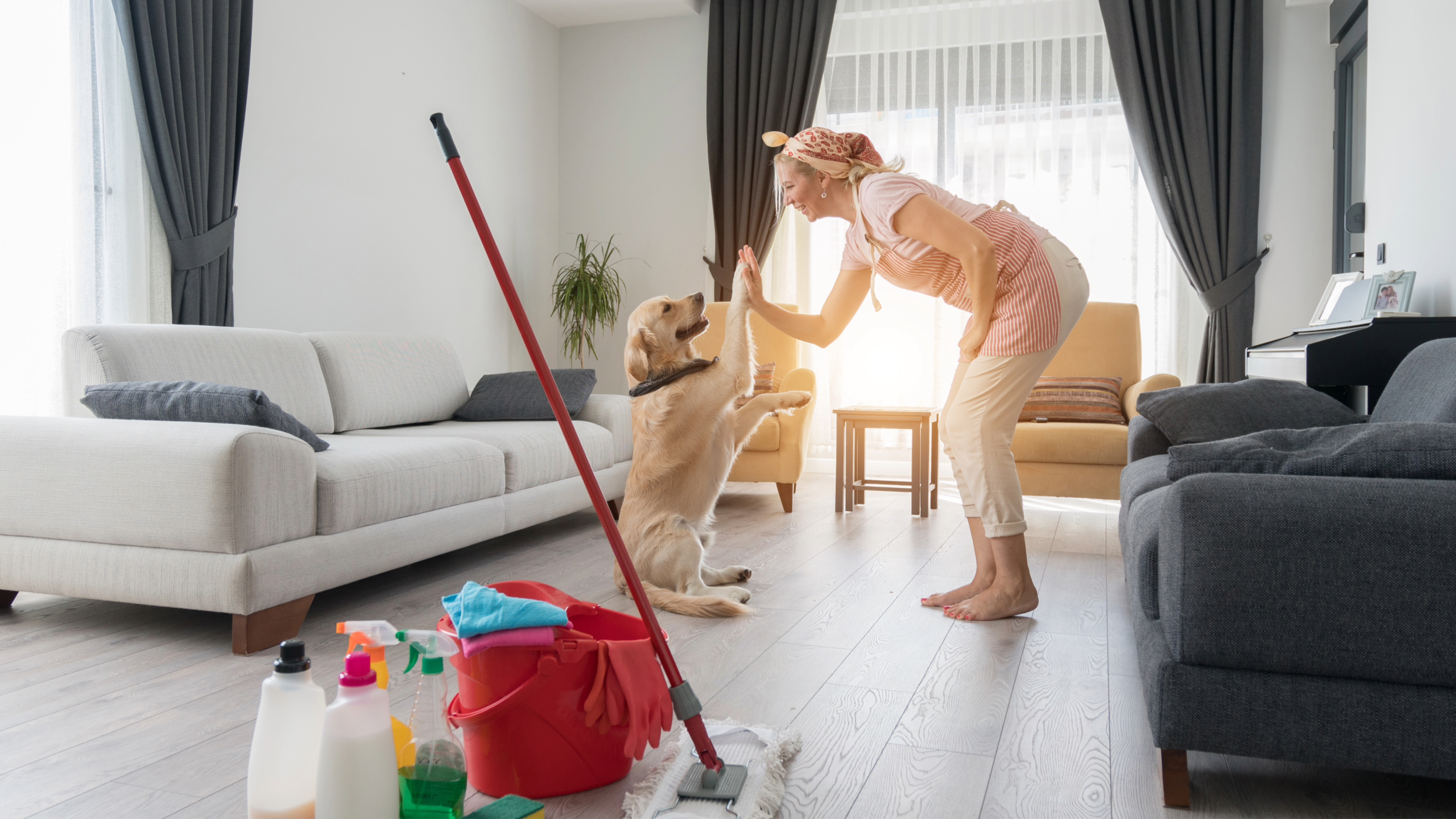 Woman giving dog a high five while cleaning