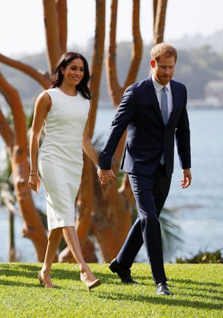 meghan markle wearing a white dress and prince harry wearing a navy suit in australia - meghan markle maternity clothes