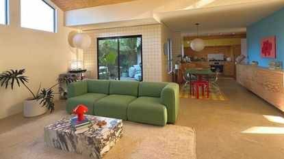 @bbrill open plan living room and kitchen with green sofa and marble block coffee table