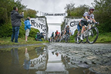 TOPSHOT - UAE Team Emirate's Slovenian rider Tadej Pogacar (R) cycles past the Pont Gibus in a cobblestone sector during the 122nd edition of the Paris-Roubaix one-day classic cycling race, 259,2 km between Compiegne and Roubaix, northern France on April 13, 2025. (Photo by Jeff PACHOUD / AFP) (Photo by JEFF PACHOUD/AFP via Getty Images)