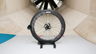 A front Zipp 404 Firecrest wheel sits in front of the fan within a wind tunnel