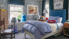 Teenage boys bedroom ideas with black and white zigzag wallpaper, a blue velvet headboard and blue blinds