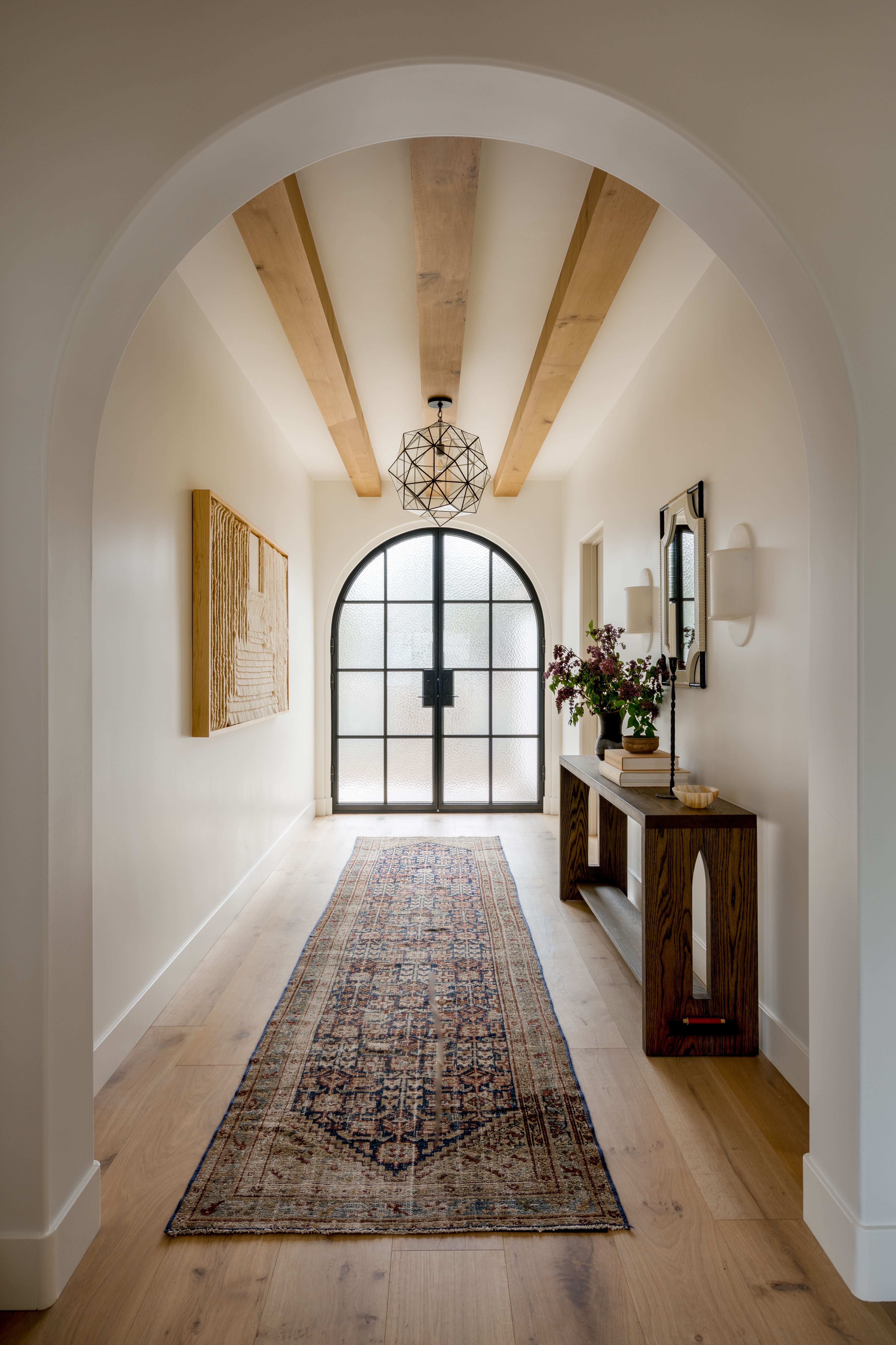 Tiled niche and hallway with arched front door