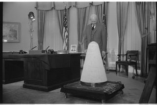 U.S. President Dwight Eisenhower looking at a nose cone in the White House during a November 1957 television speech about science and national security. He judged that he did not need a separate council for space matters, handling those issues through the National Security Council.