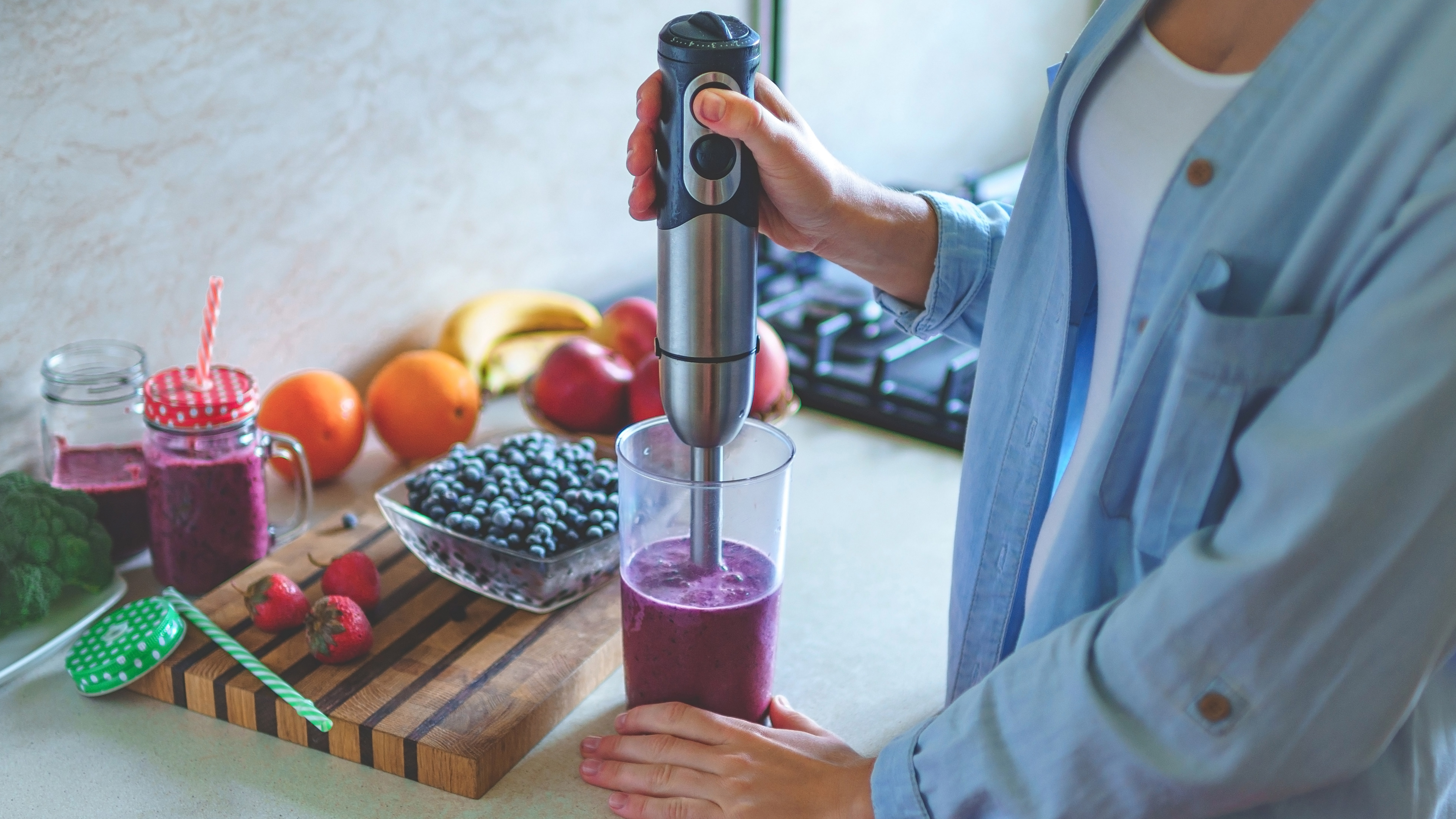 immersion blender being used in a kitchen to blitz fruit