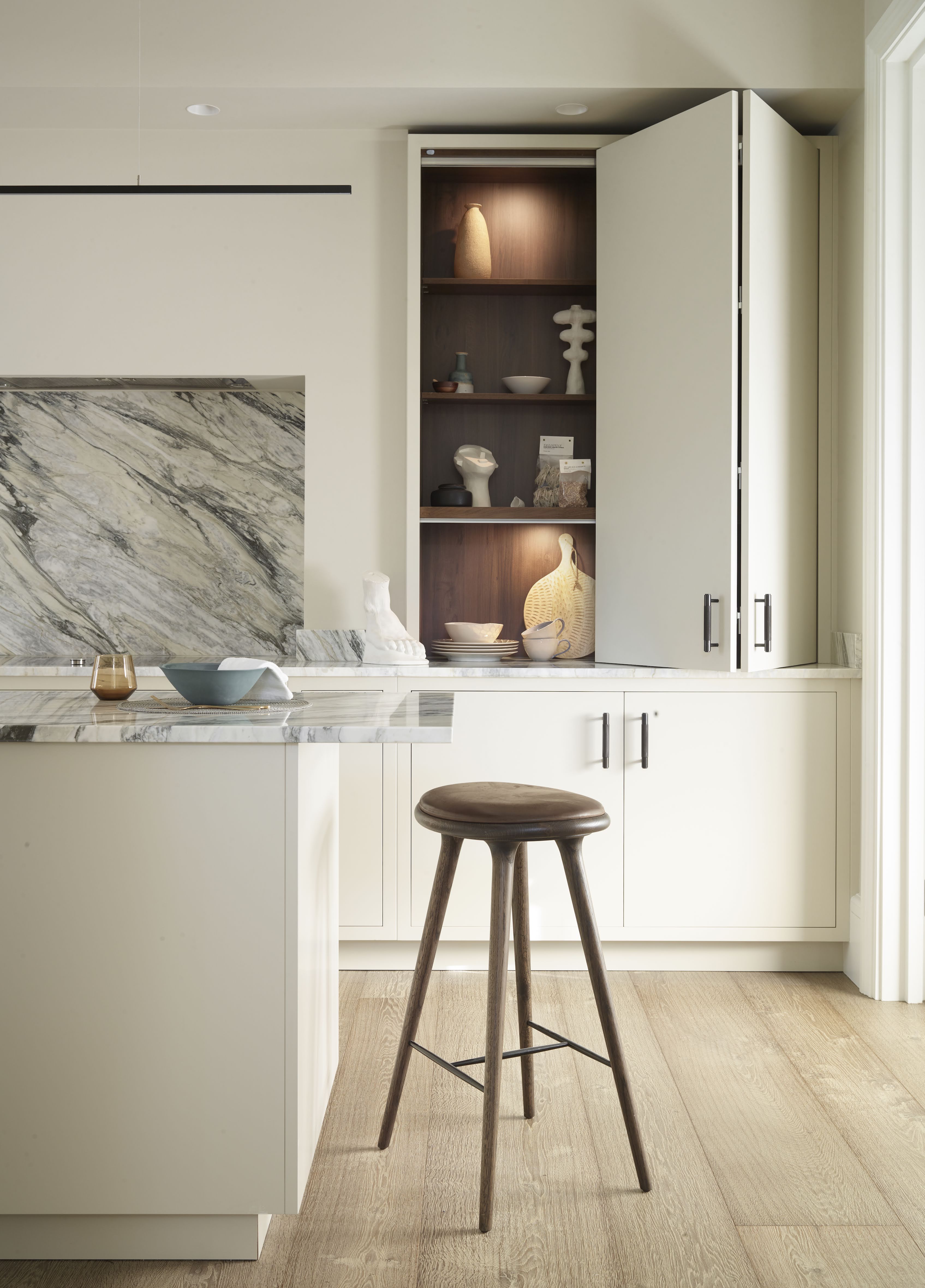 Kitchen with neutral units and open cabinet door with wood interior and lighting