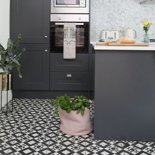 Black kichen with black and white patterned flooring