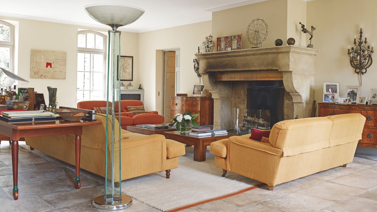 Lorenzo and Mariarosa Pellicioli home. Tan sofas, large period fireplace, assorted antique and mordern furniture.