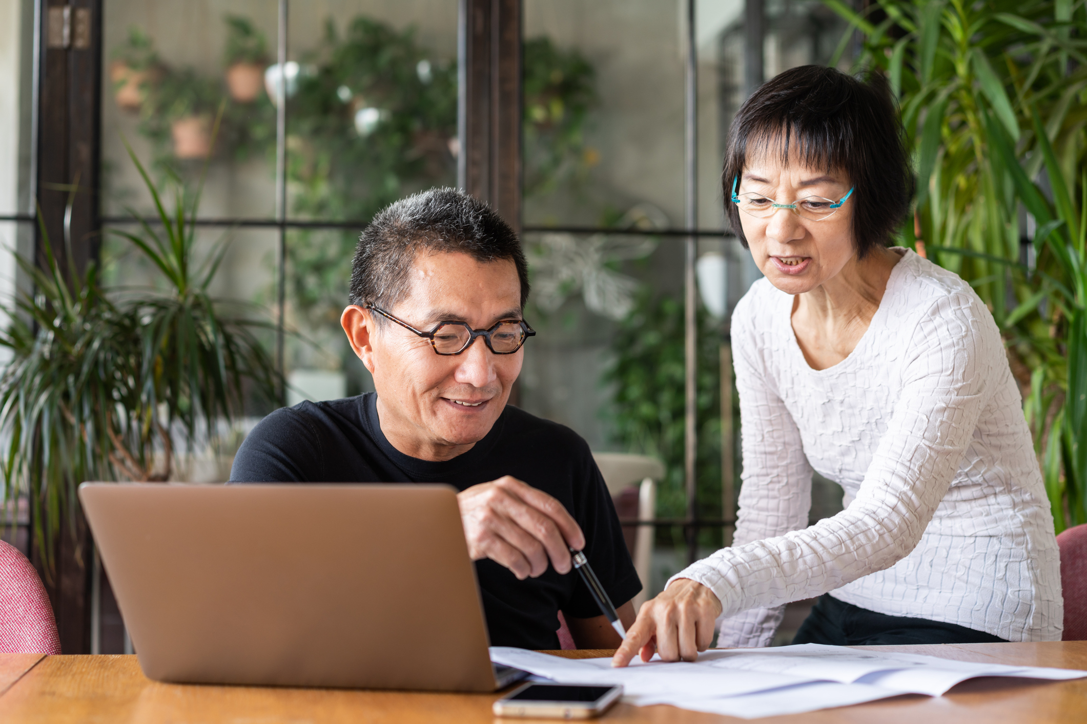 A couple reviewing their finances together at dining table.