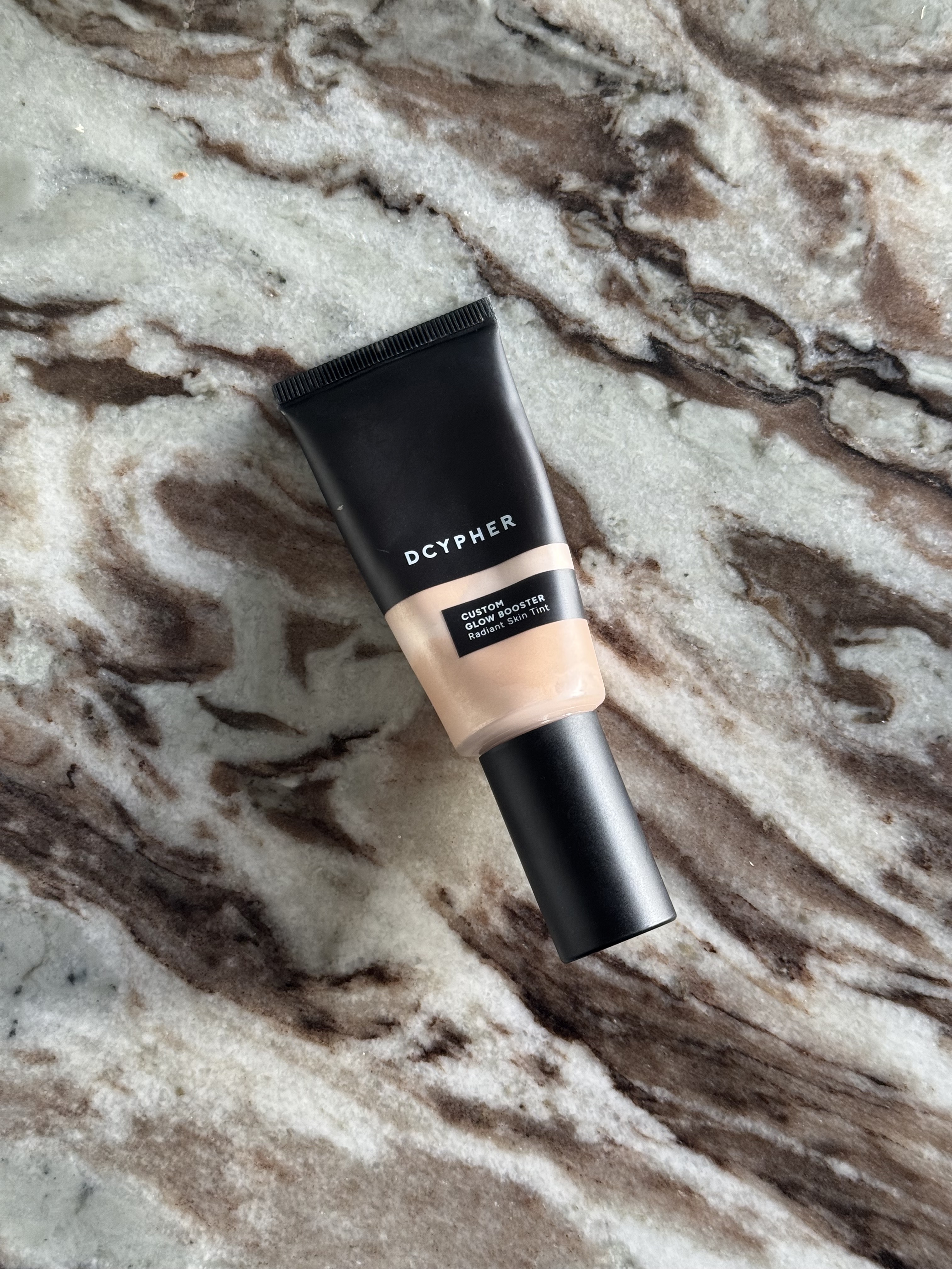 A photo of the Dcypher Custom Glow Booster on a marble table