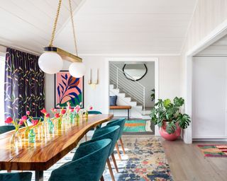dining room with white walls and colorful furniture, curtains and artwork