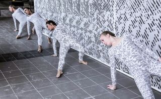 Dancers wearing similarly patterned clothing moved throughout the space