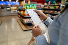 Woman shopping at a convenience store and checking her receipt