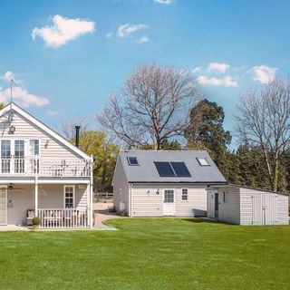 Grey shiplap house with converted garage with solar panels
