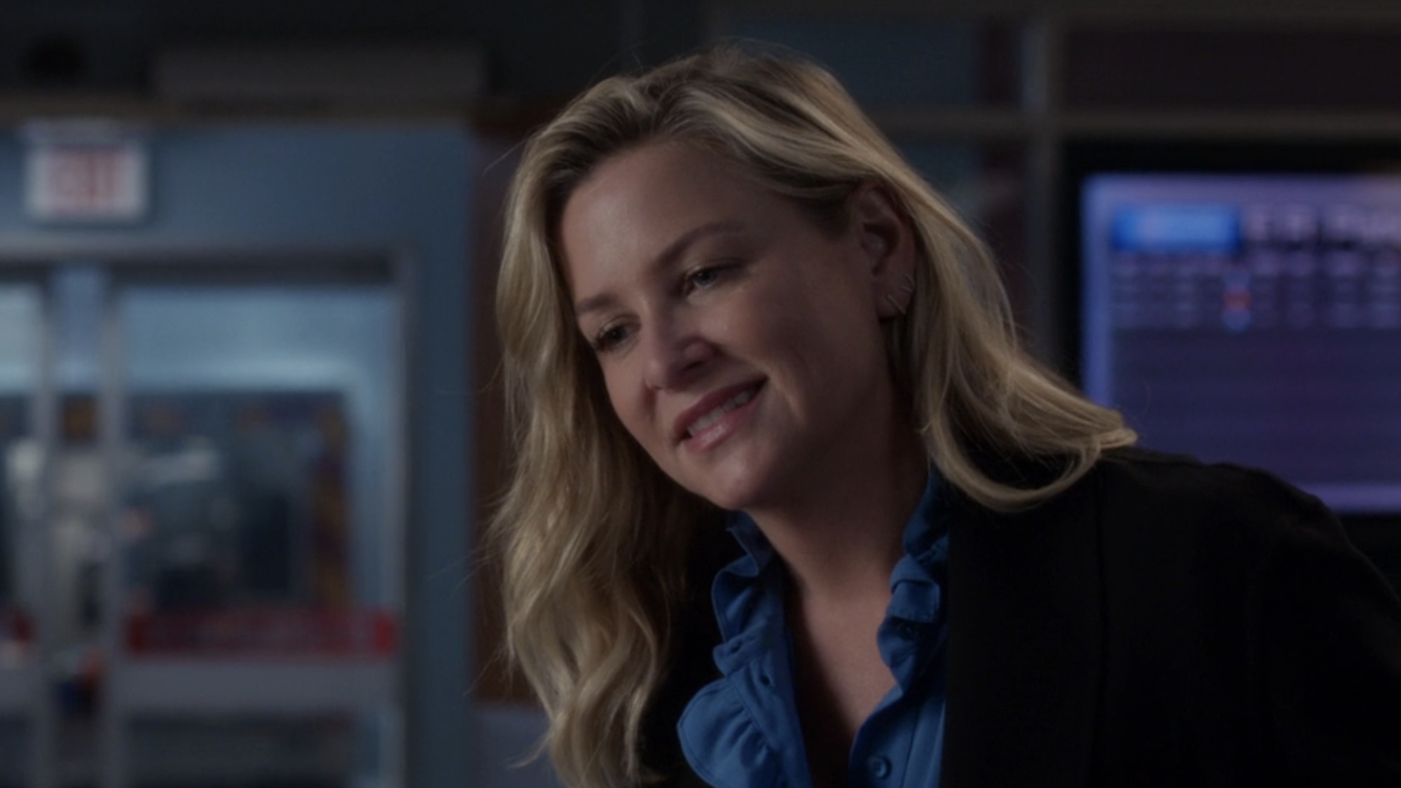 Arizona smiling in a blazer and blue shirt in the Grey's Anatomy ER.